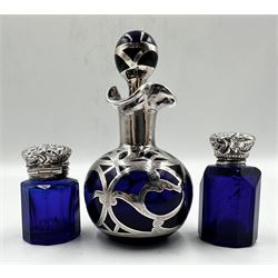 Edwardian blue glass small scent flask of facet cut design with hinged silver cover and interior glass stopper H4cm Birmingham 1901 Maker Cornelius Desormeaux Sanders and James Francis Hollings Shepherd, another similar with screw off cover, not hallmarked, and a blue glass overlaid scent flask H9cm (3) 