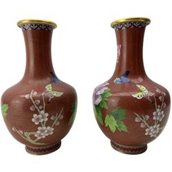 Pair of Japanese cloisonne vases, decorated with flowers, prunus and butterflies on a red ground, H26cm
