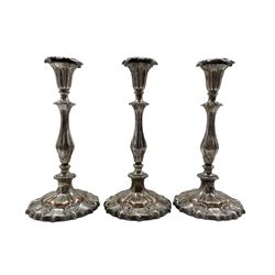 Set of three Old Sheffield plate candlesticks, baluster stems with acanthus leaf decoration, urn capitals, on shaped circular bases H29cm (3) 