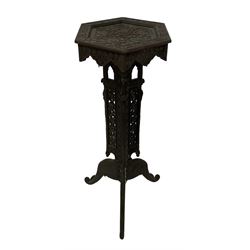 19th century carved hardwood Kashmiri plant stand or jardinier, hexagonal top with carved scrolling foliate decoration and flower heads, the tripod base with three protruding panels, each pierced with vine detail and archways with finials, the cabriole feet carved in the form of elephants with scrolling trunks