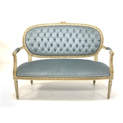Louis XV style cream and gilt painted two seat sofa, with scrolled open arms, upholstered in buttoned blue velvet, raised on turned fluted supports 