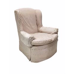 Victorian armchair, upholstered in striped fabric with squab cushion, raised on turned supports with later castors W88cm