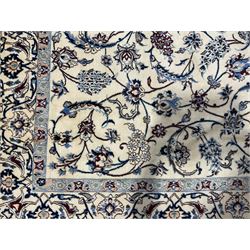 Persian Nain ivory ground rug, the field with a central floral medallion surrounded by scrolling tendrils of branches with palmettes and stylised bouquets of flower heads, the multi-band border with repeating floral patterns and leafage