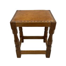 'Oakleafman' oak joint stool, rectangular seat upholstered in tan leather with studded band, on four octagonal supports joined by stretchers, carved with leaf signature, by David Langstaff of Easingwold