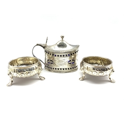 George III silver navette shape mustard pot with engraved and pierced sides and initialled 'WJW' with blue glass liner London 1791 Maker possibly Thomas Streetin and a pair of George III embossed silver circular salts, marks rubbed but possibly London 1790