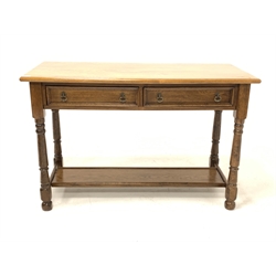 Solid oak serving table, lunette carved frieze fitted with two drawers, raised on turned supports united by stretcher 
