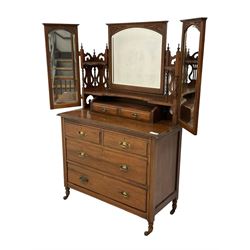 Late Victorian walnut dressing chest, triple mirror back with hinged bevelled plates, the shelves with pierced lyre supports, fitted with two short over two long drawers, on turned supports with ceramic castors