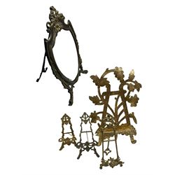 Three 20th century brass table top easels, a gilt metal easel and a brass framed dressing table mirror of shield form with ribbon top and bevelled glass plate, H34cm 