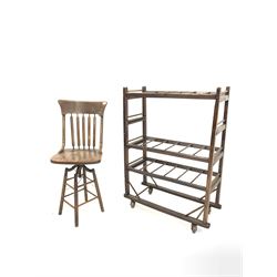 Early to mid 20th century oak and beech machinist chair, bentwood and spindle backrest over a dished seat, raised on a swivelling rise and fall base with four turned supports (W 46cm) together with an oak three tiered laundry trolley with castors (W 95cm, H 125cm, D 39cm)
