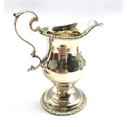 George III silver baluster cream jug embossed with trailing garlands on a pedestal foot London 1782 Maker Benjamin Mountigue and another of plain form with beaded edge London 1767, approx 6.7oz