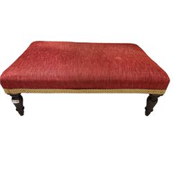 Rectangular low footstool upholstered in red fabric and raised on turned tapering supports