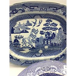 Four 19th century blue and white transfer printed meat plates decorated in the Willow pattern, together with an 'Asiatic Pheasant' pattern meat plate, largest L49cm (5) 