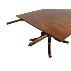 George III mahogany extending dining table, the tilt-top with two additional D-end leaves and fitted with concealed pull-out leaf rests, on turned pedestal with quadruple splayed supports with acanthus leaf carved knees, on foliate cast brass cups and castors