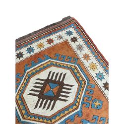 Turkish rust ground rug, two geometric medallions on plain field, the border decorated with stars within guard stripes