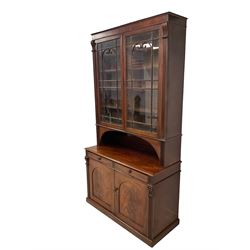 Late Regency mahogany secretaire bookcase, the top section fitted with two astragal glazed doors with C-scroll arches enclosing eight adjustable shelves, flanked by fluted column uprights, the lower section with single secretaire drawer with fitted interior, two panelled cupboard doors concealing two shelves and a single cellarette drawer, stamped 'Lodge & Co, Lancaster and Preston'