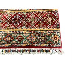 Pakistani Khurjeen multi-coloured rug, the field decorated with rows of varying geometric motifs in alternating colour, comprising lozenges and roods with stylised plant motifs