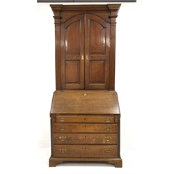 Georgian oak bureau bookcase, two arched fielded panelled doors enclosing four adjustable shelves, enclosed by fluted pilasters, over fall front revealing fitted interior, four long graduated drawers, raised on bracket supports, W97cm, H220cm, D53cm