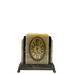 A compact 20th century Fisco French Art Deco cream onyx and gold veined black marble alarm clock raised on a shallow brass plinth with ball feet, gilt oval dial with black Arabic numerals, spade hands and alarm indicator, , timepiece alarm movement with a pin pallet escapement, wound and set from the rear.