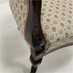 Pair of late Victorian walnut upholstered armchairs, with scrolled arm terminals, raised on floral carved cabriole supports terminating in castors, 