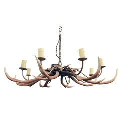 David Hunt faux stag antler chandelier, comprising eight metal branches with candle sconces, above a series of rustic painted faux antlers, W115cm approx