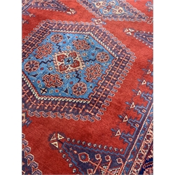 Persian rug carpet, red field with blue medallion and two lozenge medallions, guarded border decorated with stylised flower heads, 346cm x 224cm