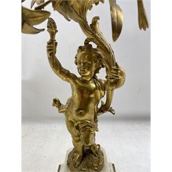 Pair of 19th century French ormolu candelabra in Louis XVI style each with five naturalistic scrolling floral and foliate branches, each supported by a cherub holding a flaming torch on marble bases with compressed circular feet H64cm  Provenance:  3rd Earl of Feversham