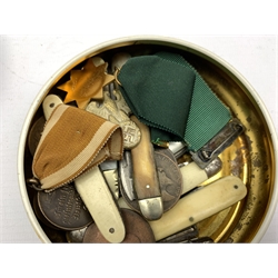 Tin containing a number of fruit and pen knives, coins, German bronze medal 1933 etc