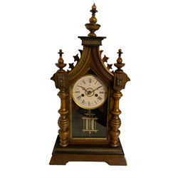 Juhngans - late 19th-century 8-day walnut and ebony mantle clock, with a spire pediment and canted plinth, matching turned finials, ring-turned half-pilasters and fully glazed door displaying a card dial with Roman numerals, moon steel hands and a faux twin file mercury pendulum, two train count wheel striking movement, striking the hours and half hours on a coiled going. With pendulum and key.