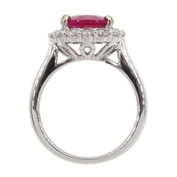 White gold oval ruby and round brilliant cut diamond cluster ring, stamped 18K 750, ruby approx 3.75 carat, total diamond weight approx 0.40 carat