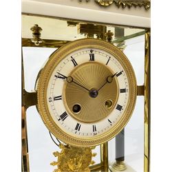 French - Late 19th century 8-day mantel clock in the Empire style, with matching white marble garniture de chiminea, two part dial with a narrow enamel chapter, roman numerals and an engine turned centre and ornate bezel to the edge, four reeded column supports, applied cast gilt metal swags on cast bracket feet, visible pendulum decorated with Greek mask surrounded by grapes and vine leaves, twin train rack striking movement, striking the hours and half hours on a suspended coiled gong, with a conforming pair of white marble urn garnitures with gilt metal handles on a stepped square base