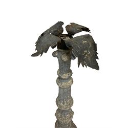 Pair of 20th century composite stone candle stands, with pressed metal collars or candle sconces in the form of splayed leaves, the pedestals cast with acanthus leaves and flower head decoration