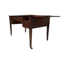 George III mahogany library table or desk, rectangular top with moulded edge, extending brushing slides to each side, fitted with central frieze drawer flanked by two small drawers, faux drawers to the reverse and sides with ebony stringing and key holes, raised on square tapering supports terminating in brass cups and castors