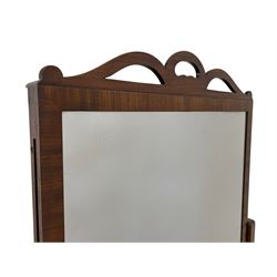 Early 19th century mahogany cheval dressing mirror, ribbon shaped pediment, the rectangular plate on an adjustable sliding sash with panelled back, retractable  stands to either side, raised on splayed end supports with brass capped feet and castors 