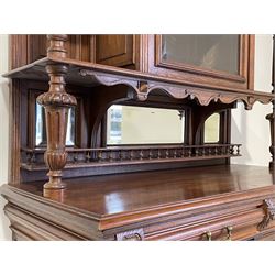 Pair late 19th century oak buffet cabinets, projecting moulded cornice over display cabinet enclosed by arched glazed door, two shelves either side with turned support, moulded rectangular top over two drawers and two cupboards, the panelled doors carved with scrolling foliate and putti masks, turned and fluted upright pilasters, on turned feet