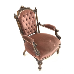 Victorian mahogany open armchair, floral carved cresting rail over deep buttoned upholstered back, padded arm rests with scroll and leaf carved terminals, raised on turned and fluted supports and brass castors, W66cm
