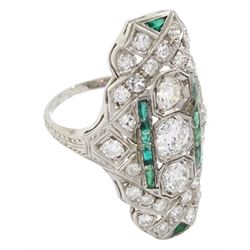 Platinum milgrain set round diamond and vari-cut emerald panel ring, with engraved decoration shoulders, stamped Plat, the three central diamonds total weight approx 0.90 carat