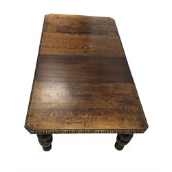 Victorian oak extendable dining table, the extending top with carved edge over profusely carved turned supports, terminating in ceramic castors 
