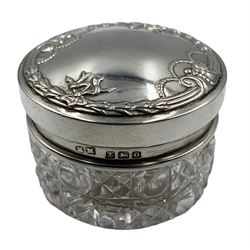 Embossed silver upright table photograph frame with oval aperture 12cm x 9cm Birmingham 1912, five glass dressing table jars with silver covers and a scent bottle
