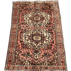 Vintage Persian faded red ground rug, with double medallion on floral field, geometric foliate to border 254cm x 157cm