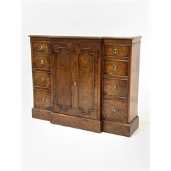 Regency style walnut breakfront bookcase, boxwood strung top over double cupboard enclosing two adjustable shelves and two banks of four graduated drawers, raised on skirted base W113cm, D32cm, H92cm