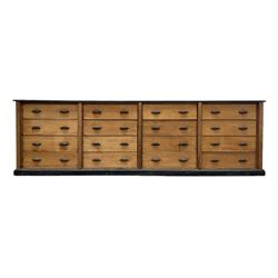 Early to mid-20th century pine multi-drawer unit, moulded rectangular top over sixteen drawers, on skirted base