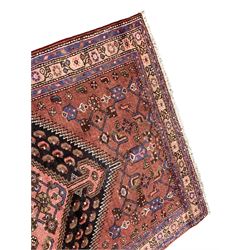 Persian Shiraz rose ground rug, the large hexagonal medallion containing and surrounded by Herati motifs with stylised bird symbols and flower heads, the guarded border with repeating trailing floral designs