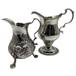 Early George III silver baluster cream jug with C scroll handle H11cm, marks rubbed but circa 1774 and another with later embossed decoration 5.9oz (2)