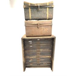 Early 20th century printers cabinet, sheet metal frame fitted with nineteen stained pine drawers with divisions for printing blocks of various sizes, one drawer missing, (W90cm, H108cm, D54cm)together with two dome top tin trunks (70cm) 