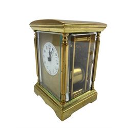 A late 19th century Parisian spring driven table clock with four bevelled glass panels, brass case with a convex top and shaped stepped base, gilt dial mask and circular white enamel dial with upright Arabic’s and minute markers,  non-matching fleur de Lis hands, eight-day spring driven movement with rack striking, sounding the hours and half-hours on a coiled gong, with a jewelled lever platform escapement, balance with regulation and timing screws, original baseplate cover, movement backplate stamped “Made in France” With key.
