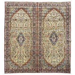Persian double Kerman ivory ground carpet, the busy field decorated with trailing branches and stylised plant motifs, indigo ground central medallion with floral design, the border decorated with repeating flower head and foliage pattern, with guard stripes