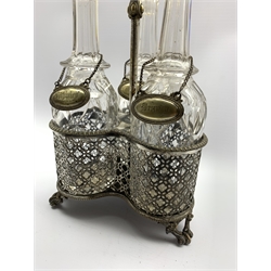 Early 20th century silver-plated three division decanter stand with loop handle, pierced sides and fitted with three glass decanters with plated labels