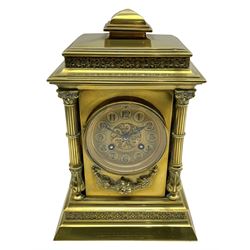 Brass cased eight-day French mantle clock c 1910, with a stepped pediment and applied decorative frieze, recessed reeded pillars to the front of the case on a conforming stepped plinth with a canted base, gilt dial with a pierced circular boss to the centre, cameo Arabic numerals and steel fleur di Lis hands, striking movement, striking the hours and half hours on a coiled gong. With pendulum and key.   