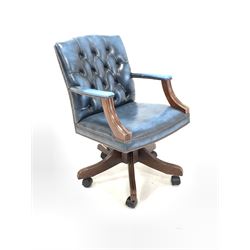 20th century stained beech desk chair, upholstered in buttoned blue leather, open arm rests with moulded curved terminals, raised on a five point swivel base with castors W56cm