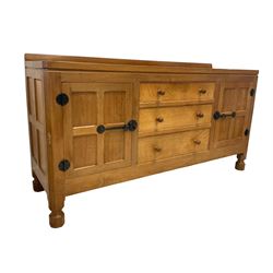 Mouseman - adzed oak sideboard, raised back over rectangular top, fitted with three central graduating drawers flanked by two panelled cupboards with wrought metal hinges and fittings, raised on octagonal supports, carved with mouse signature, by the workshop of Robert Thompson, Kilburn